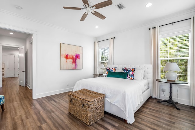 bedroom with dark hardwood / wood-style flooring, ceiling fan, and crown molding