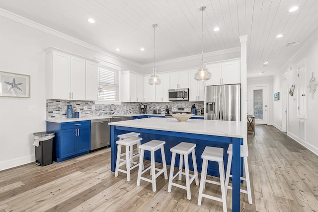 kitchen featuring blue cabinets, a breakfast bar, tasteful backsplash, hanging light fixtures, and stainless steel appliances