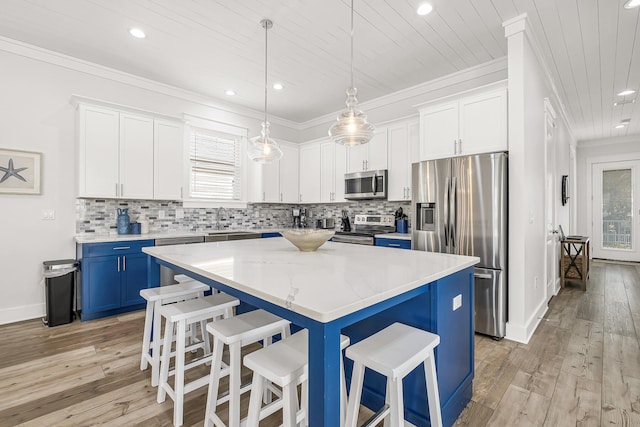 kitchen with a kitchen island, a breakfast bar, light wood-type flooring, decorative light fixtures, and stainless steel appliances