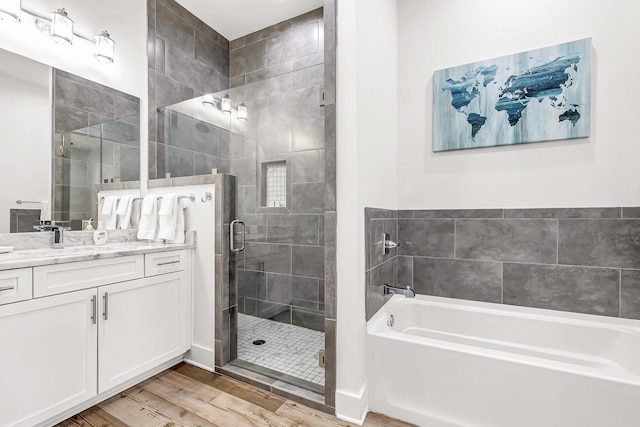 bathroom featuring wood-type flooring, vanity, and separate shower and tub