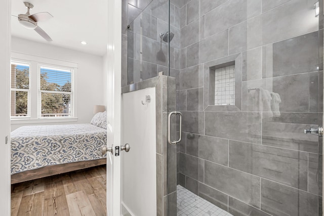 bathroom featuring wood-type flooring, ceiling fan, and an enclosed shower