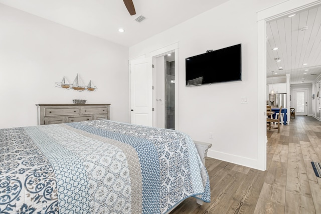 bedroom featuring ceiling fan with notable chandelier and light wood-type flooring