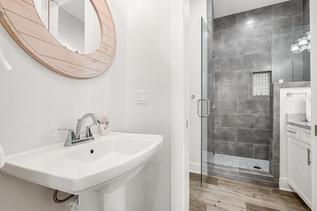 bathroom with a shower with door and hardwood / wood-style flooring