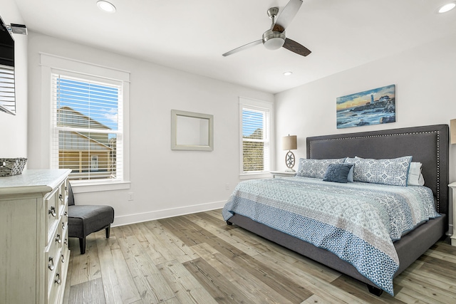 bedroom with ceiling fan, light hardwood / wood-style floors, and multiple windows