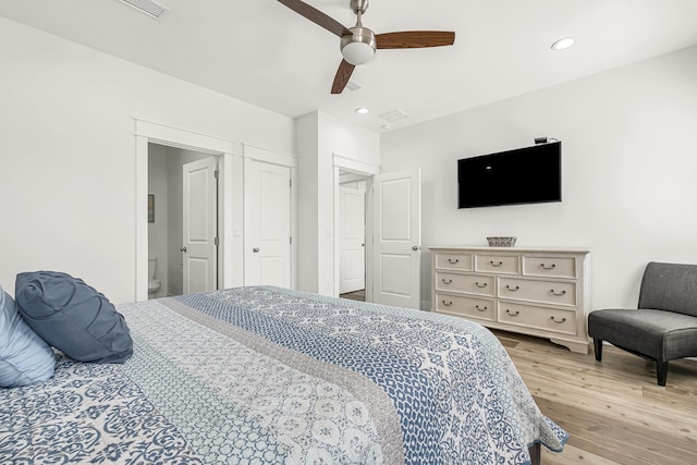 bedroom featuring ensuite bath, light hardwood / wood-style floors, and ceiling fan