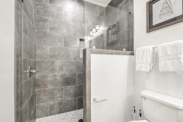 bathroom with toilet and a tile shower