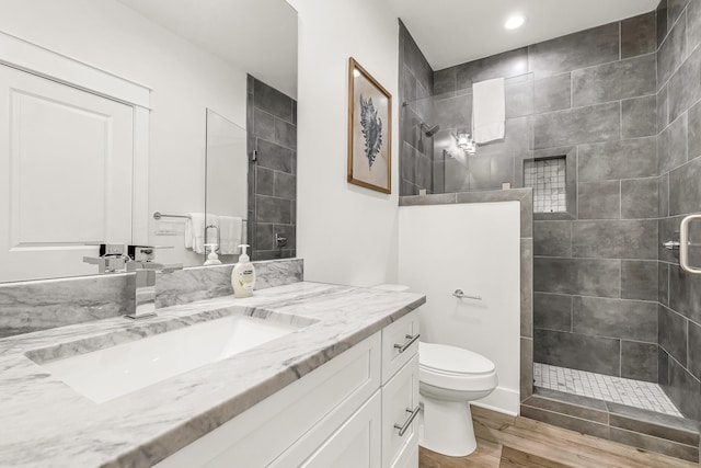 bathroom featuring a shower with door, wood-type flooring, vanity, and toilet