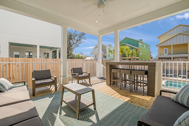 view of patio / terrace featuring exterior bar, a swimming pool side deck, ceiling fan, and an outdoor hangout area