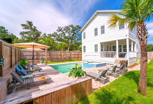 view of swimming pool featuring a yard, an in ground hot tub, and a patio area