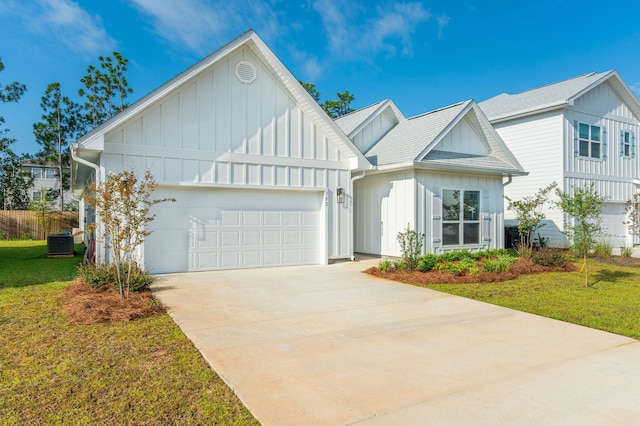 view of front facade with central AC unit, a garage, and a front yard