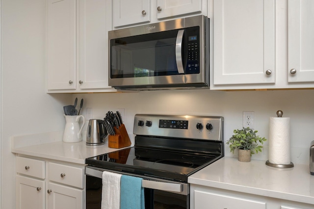 kitchen with white cabinets and appliances with stainless steel finishes