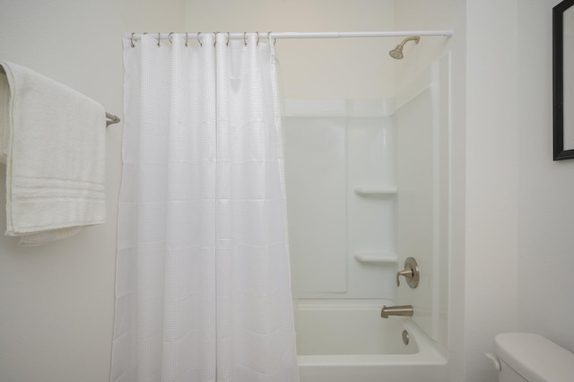 bathroom featuring shower / bath combo with shower curtain and toilet