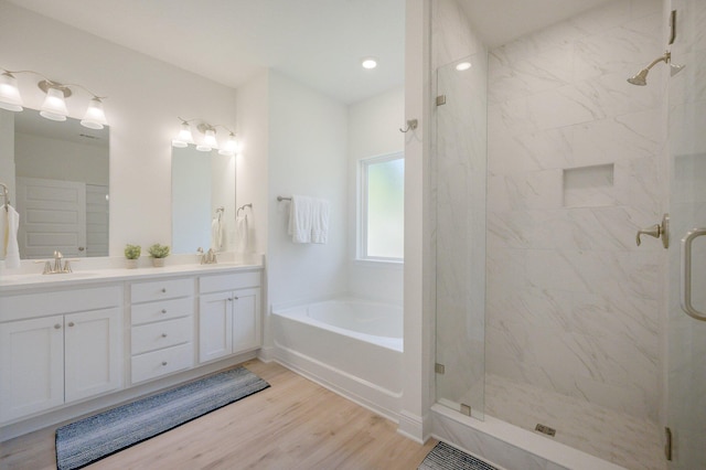 bathroom with hardwood / wood-style flooring, vanity, and independent shower and bath