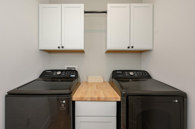 washroom featuring cabinets and washer and dryer