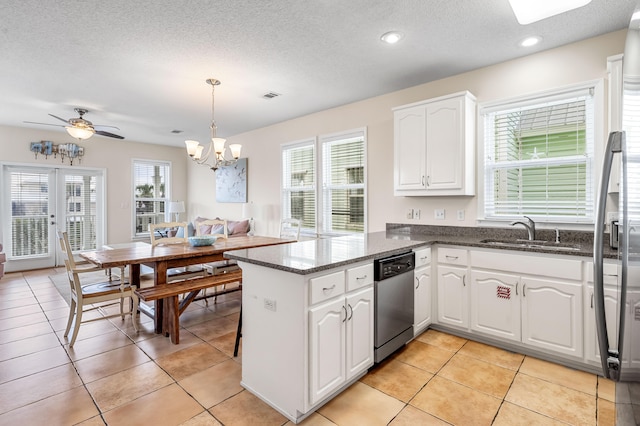 kitchen featuring sink, decorative light fixtures, light tile flooring, and stainless steel dishwasher