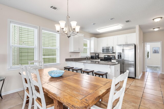 tiled dining area with sink and a notable chandelier