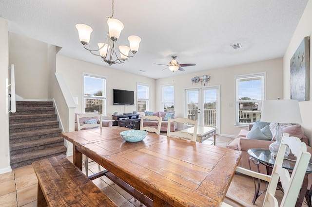 dining room featuring ceiling fan with notable chandelier, french doors, and light tile flooring