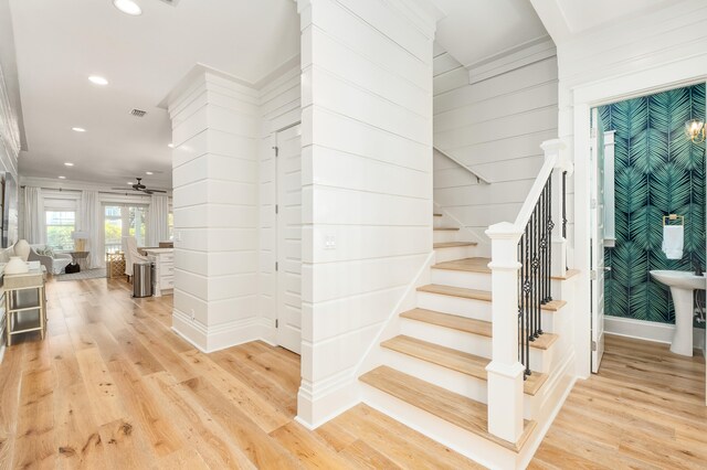 staircase with ceiling fan and light wood-type flooring