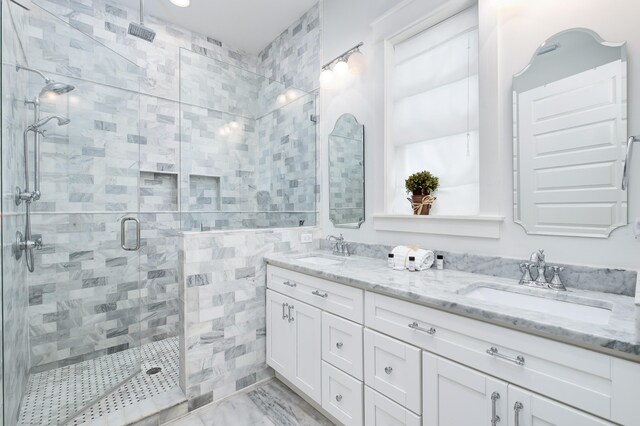 bathroom featuring an enclosed shower and dual bowl vanity