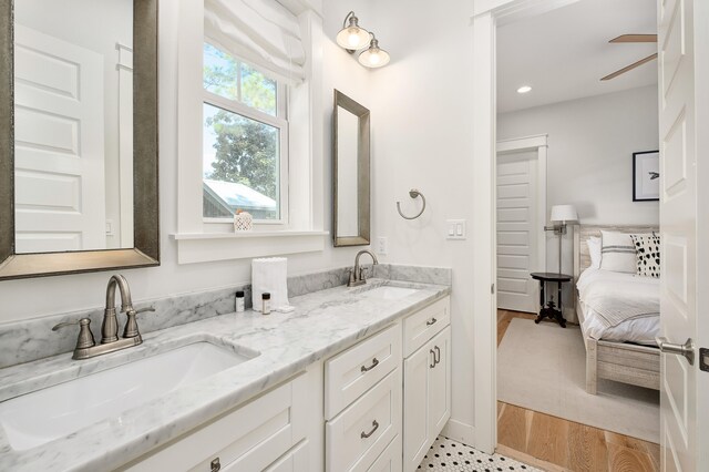 bathroom with double sink, oversized vanity, ceiling fan, and hardwood / wood-style floors