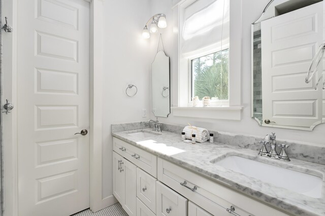 bathroom featuring dual sinks, oversized vanity, and tile flooring