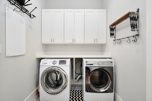 washroom with cabinets and washing machine and clothes dryer