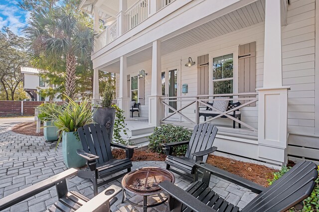 view of patio featuring an outdoor fire pit and a porch