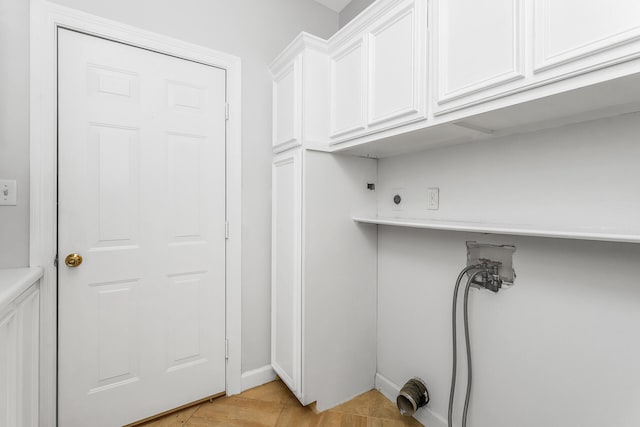 laundry room with cabinets, light tile flooring, hookup for a washing machine, and electric dryer hookup