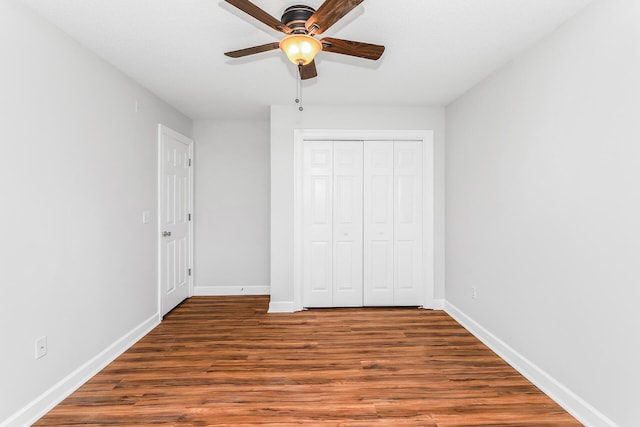 unfurnished bedroom with a closet, ceiling fan, and dark hardwood / wood-style flooring