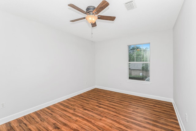 spare room with a textured ceiling, ceiling fan, and dark wood-type flooring