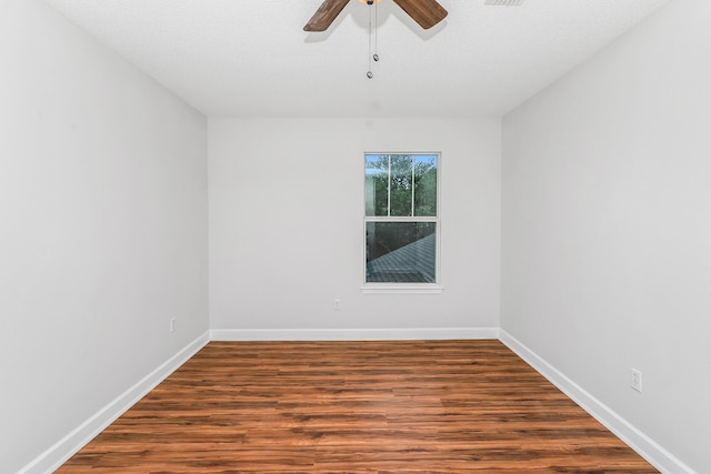 spare room featuring dark hardwood / wood-style flooring, ceiling fan, and a textured ceiling