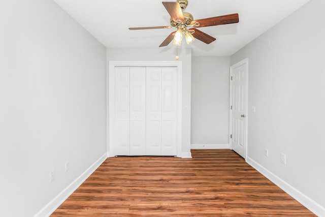 unfurnished bedroom featuring a closet, dark hardwood / wood-style flooring, and ceiling fan