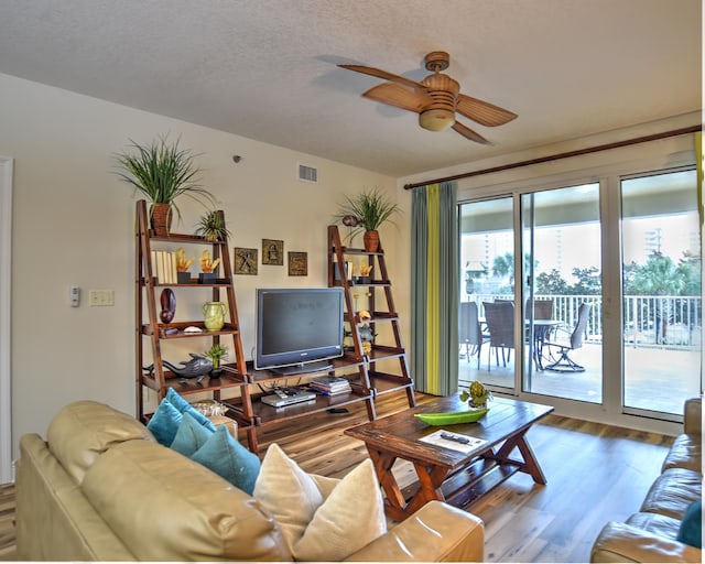 living room featuring plenty of natural light, ceiling fan, and dark hardwood / wood-style floors