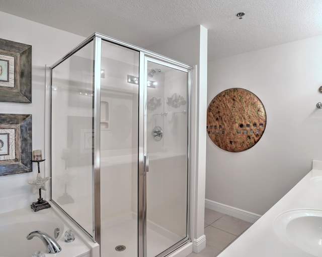 bathroom with tile flooring, independent shower and bath, and a textured ceiling