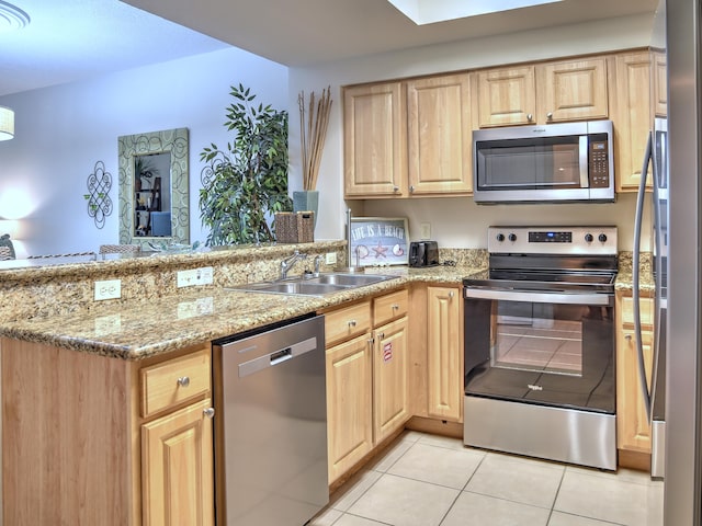 kitchen with sink, stainless steel appliances, light stone countertops, and light tile flooring