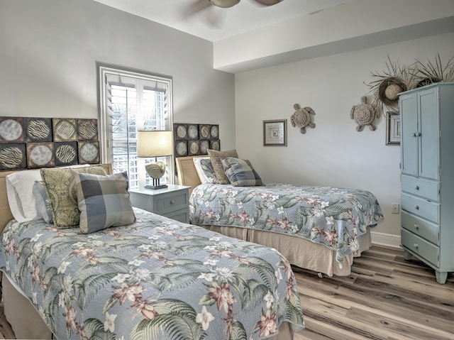 bedroom with dark hardwood / wood-style flooring and ceiling fan