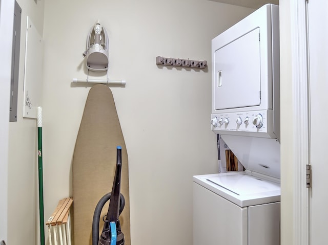 clothes washing area with stacked washing maching and dryer