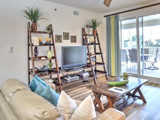 living room featuring wood-type flooring and ceiling fan