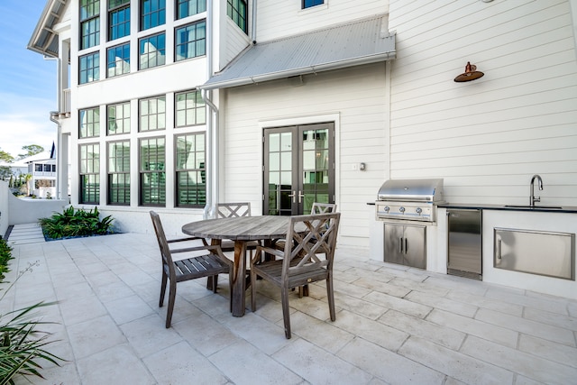 view of terrace featuring exterior kitchen, a grill, and sink