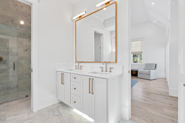 bathroom featuring double sink, vaulted ceiling, an enclosed shower, and hardwood / wood-style floors