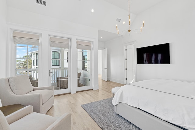 bedroom featuring light hardwood / wood-style floors, high vaulted ceiling, and a notable chandelier