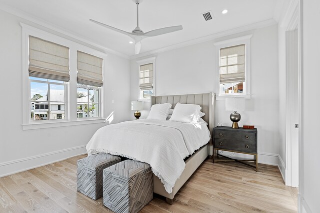 bedroom with light hardwood / wood-style flooring, ceiling fan, and ornamental molding