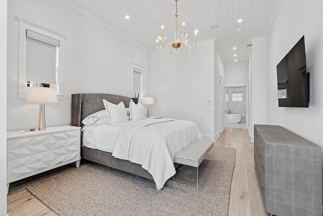 bedroom with ornamental molding, connected bathroom, light hardwood / wood-style floors, and an inviting chandelier