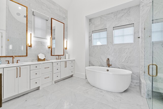 bathroom with a shower with door, double sink vanity, tile walls, and tile floors