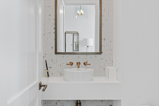 bathroom featuring sink and backsplash