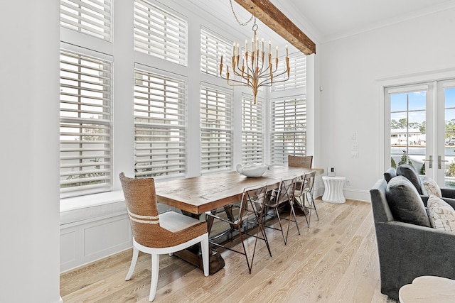 dining space featuring beam ceiling, light wood-type flooring, and a chandelier