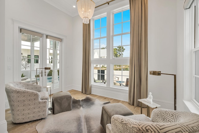 living area featuring light hardwood / wood-style flooring, french doors, and an inviting chandelier