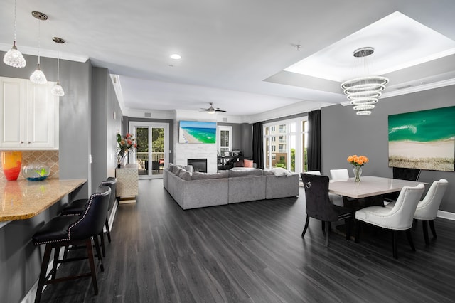 dining space featuring ornamental molding, dark hardwood / wood-style flooring, and ceiling fan with notable chandelier