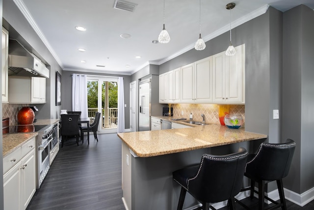 kitchen with white cabinetry, hanging light fixtures, a kitchen breakfast bar, stainless steel appliances, and kitchen peninsula