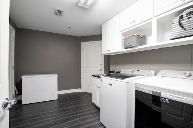 laundry room featuring dark wood-type flooring, cabinets, sink, and washer and dryer